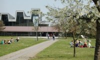 Die Campuswiese im Frühling mit dem naturwissenschaftlichen Hörsaalgebäude.