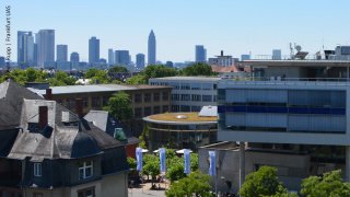 Blick auf den Campus mit der Mensa (Rundbau) und der Frankfurter Skyline im Hintergrund