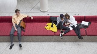 Studierende auf dem roten Sofa der UW/H